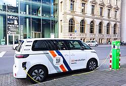 Ein Elektroauto steht an der Ladesäule in einer Großstadt.
