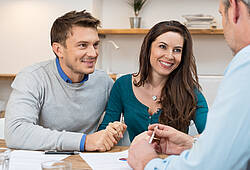 Ein junges Paar lässt sich von einem Bankberater beraten (Symbolfoto).