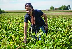 Eine Frau steht in einem Soja-Feld in Bayern.