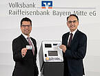 Andreas Streb (links) und Richard L. Riedmaier von der Volksbank Raiffeisenbank Bayern Mitte stellen die VR-BitcoinGoCard vor.