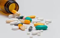 Tabletten und Pillen fallen aus einer braunen Tablettenflasche.