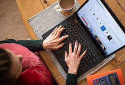 Symbolbild: Eine Frau sitzt an einem Notebook und surft im Internet.