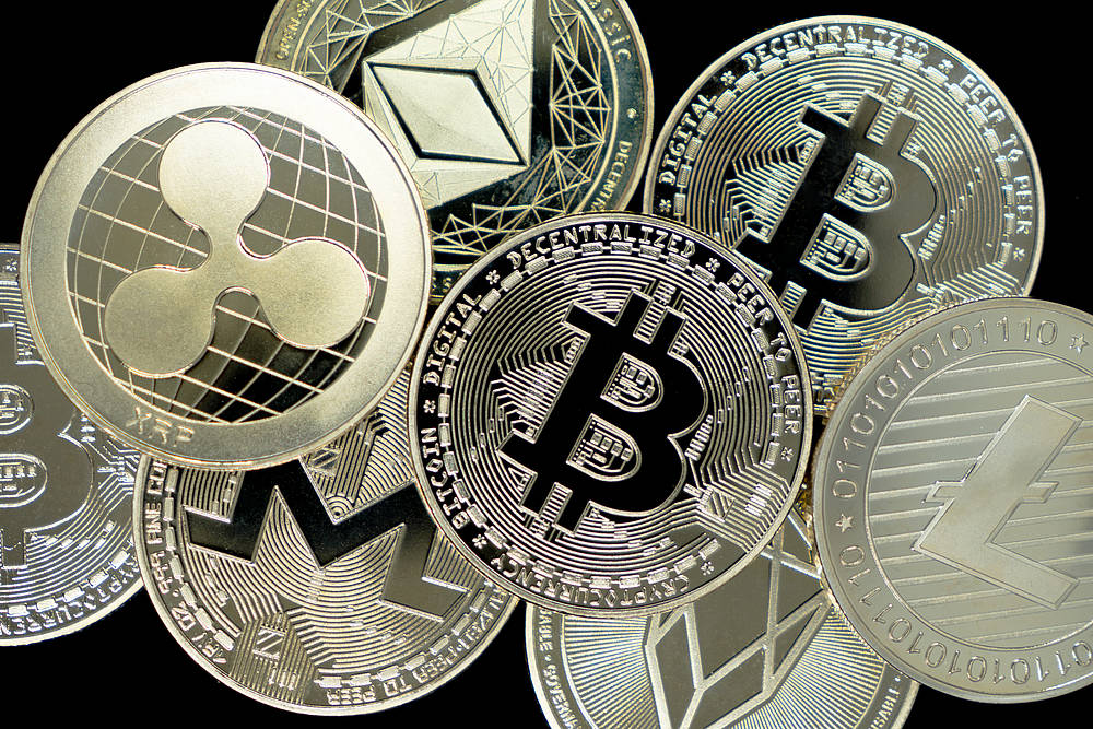 Münzen stehen für die Kryptowährungen Bitcoin, Ripple oder Ethereum.