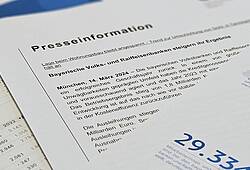 Die Pressemitteilung und ein Faktenblatt zur Bilanz 2023 der bayerischen Volksbanken und Raiffeisenbanken liegen auf einem Tisch.