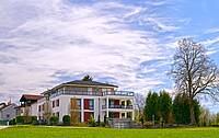 Ein Mehrfamilienhaus mit einem großen Garten.