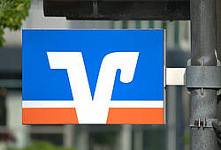 Ein Schild mit dem Logo der VR-Banken ist an einer Laterne befestigt.