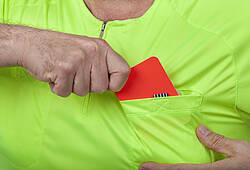 Ein Schiedsrichter zieht eine rote Karte.