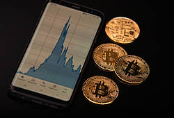 Symbolische Bitcoin-Münzen und eine Chart-Grafik.