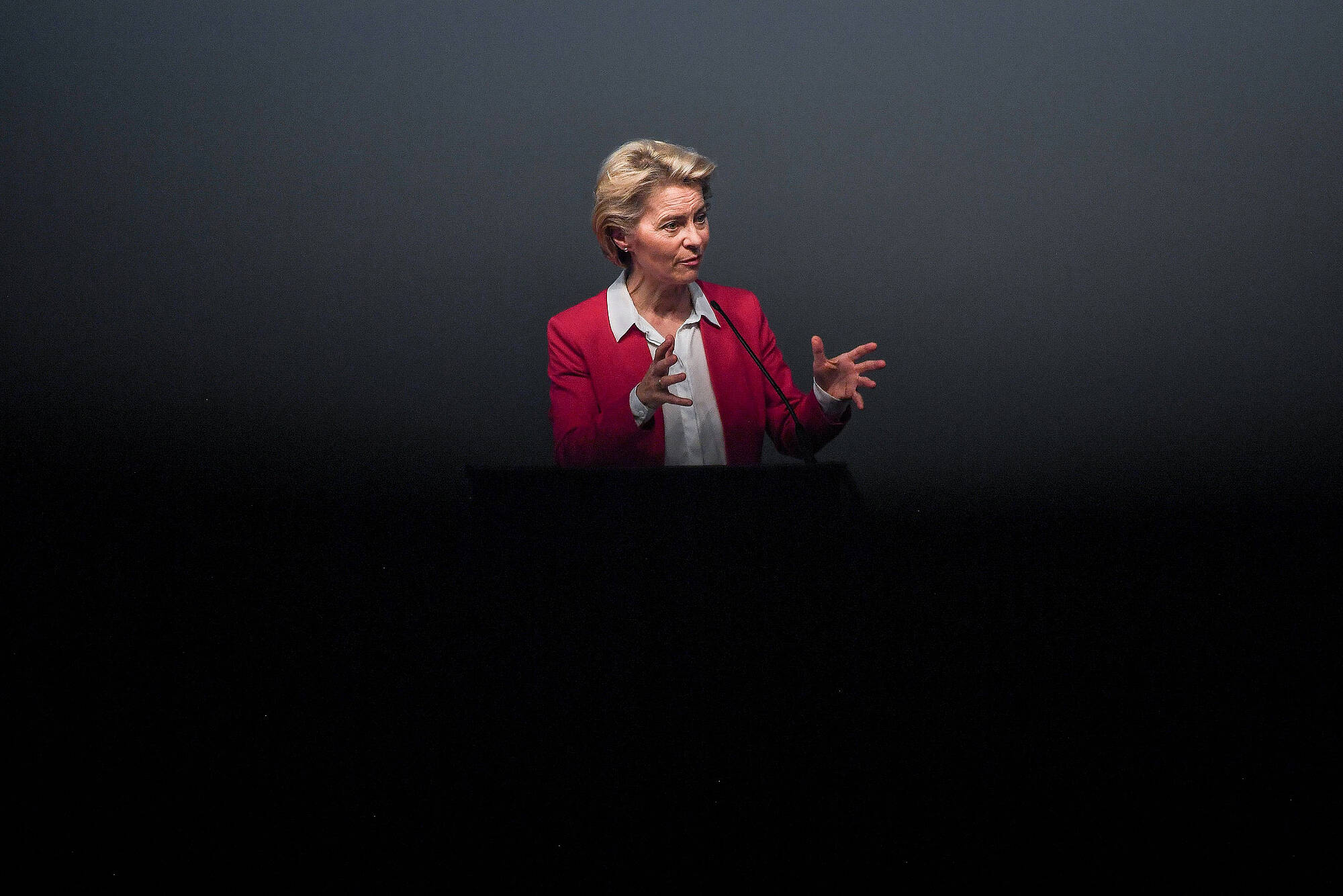 Ursula von der Leyen hält eine Rede vor dunklem Hintergrund.