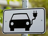 Ein Schild weist auf eine E-Tankstelle für Autos hin.