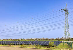 Eine Stromtrasse für über ein Solarfeld.